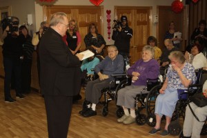 Bishop Dennis Sullivan prays with and blesses the residents of Kennedy Health Care Center.