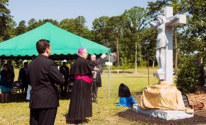 Above: Bishop Dennis Sullivan and Father Michael Romano listen as South Jersey Catholic Cemeteries director Marianne Linka speaks at the dedication ceremony at the newly expanded Gate of Heaven Cemetery in Berlin on June 22.  Below: Bishop Sullivan blesses a new crucifix on the grounds.
